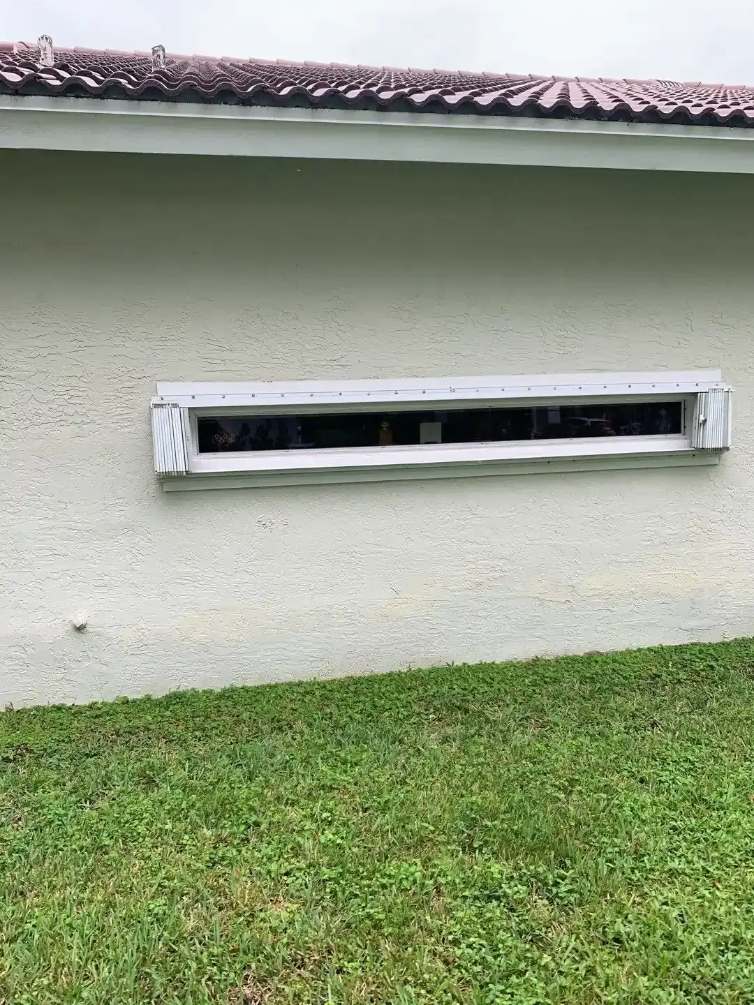 Accordion shutter track and housing installed above a window