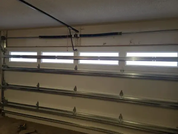 Interior view of a garage door showing reinforcement struts, track and torsion spring shaft
