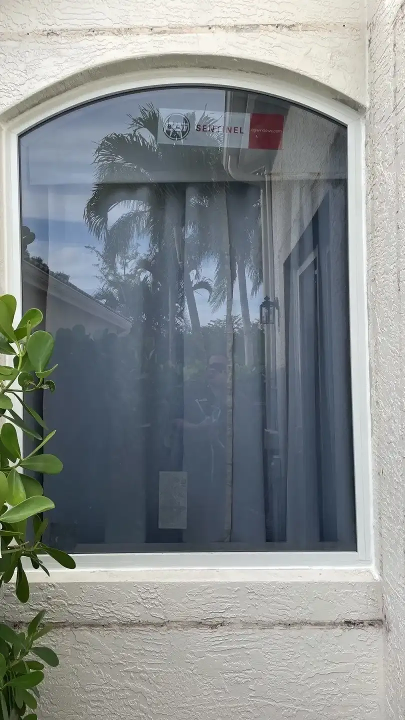 Impact windows installed across the front of a stucco South Florida home